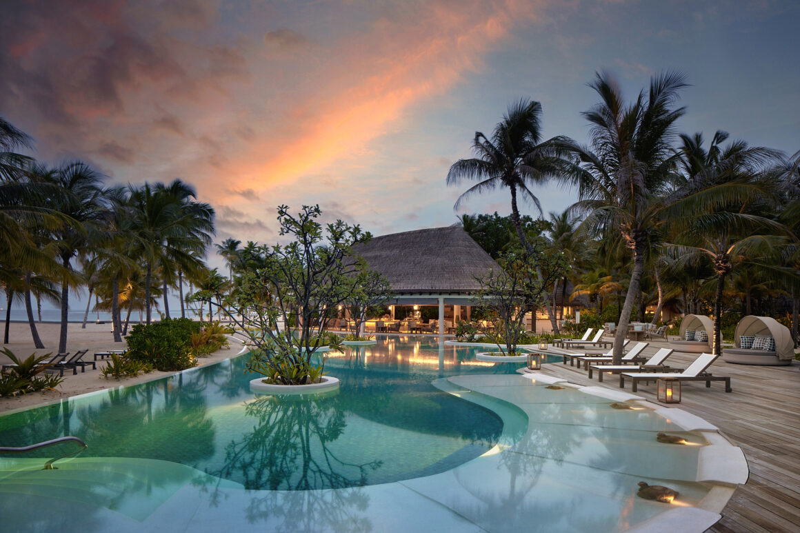 Aerial view of Six Senses Kanuhura, a private island resort in the Maldives surrounded by turquoise waters and white sand beaches.