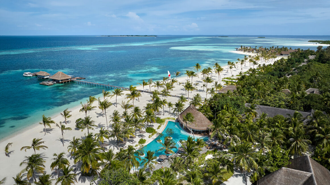Aerial view of Six Senses Kanuhura, a private island resort in the Maldives surrounded by turquoise waters and white sand beaches.